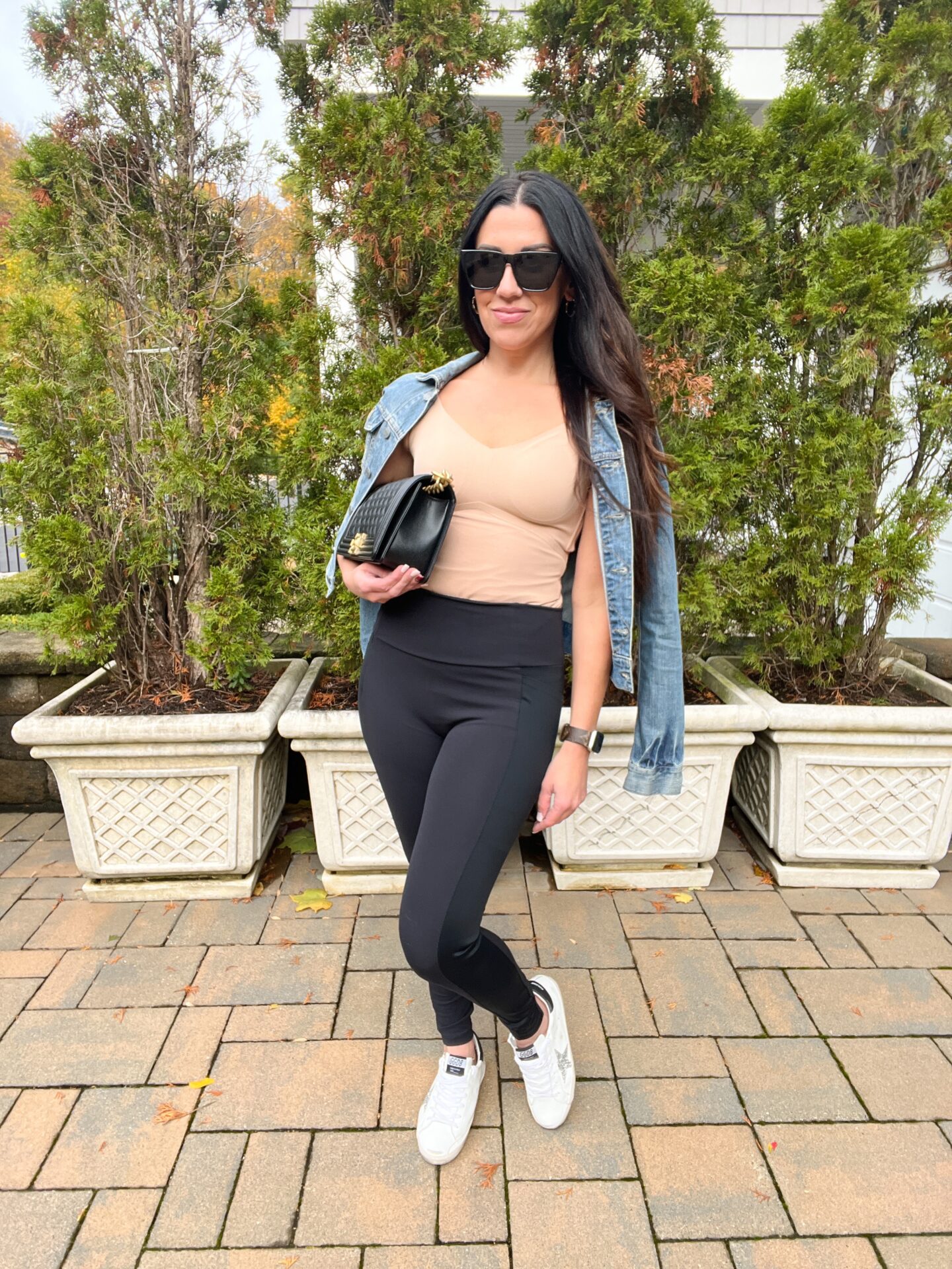 woman in leggings, nude top, and denim jacket